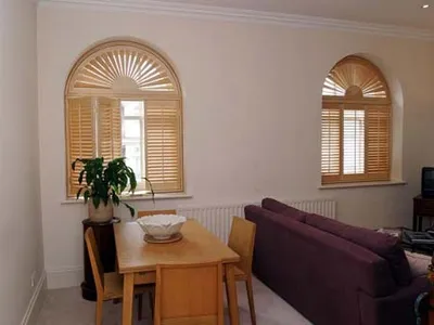 Shaped shutters fitted to an arched window